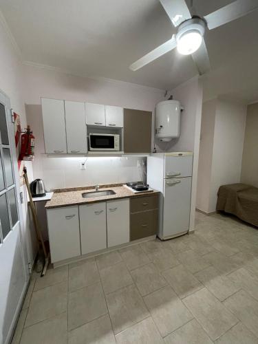 a kitchen with white cabinets and a white refrigerator at Costa Termal 9 in Chajarí