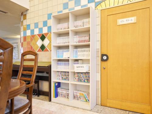 a book shelf with books in it next to a door at Hotel Fukui Castle - Vacation STAY 58692v in Fukui