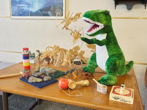 a dinosaur toy sitting on a table with other toys at Hotel Fukui Castle - Vacation STAY 58692v in Fukui