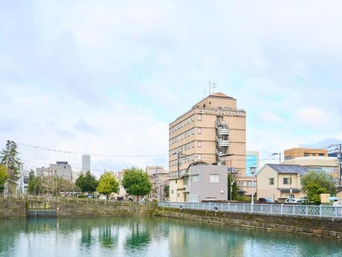 a river in a city with a tall building at Hotel Fukui Castle - Vacation STAY 58692v in Fukui