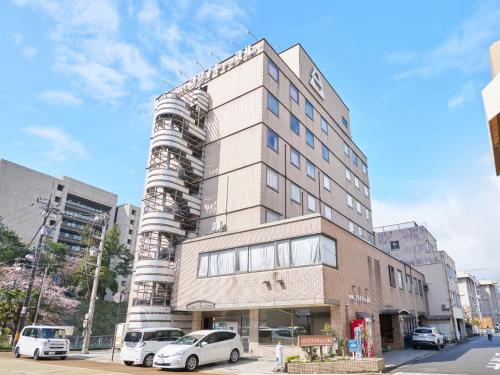 a tall building with cars parked in front of it at Hotel Fukui Castle - Vacation STAY 58692v in Fukui