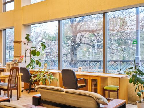 a lobby with a large window with chairs and tables at Hotel Fukui Castle - Vacation STAY 58692v in Fukui
