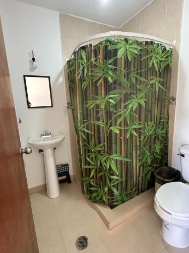 a bathroom with a shower with a bamboo shower curtain at Casa AmaNacer Malinalco in La Ladrillera