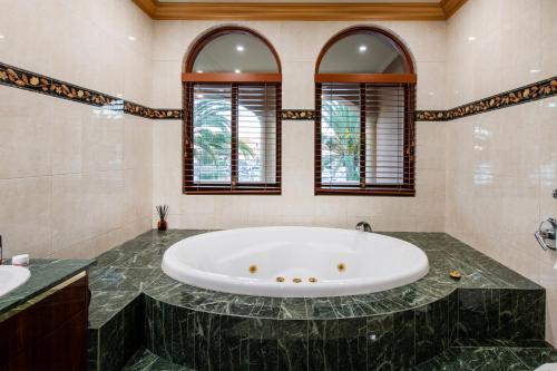 a large bathroom with a large tub and two windows at Bellagio Gold Coast in Gold Coast