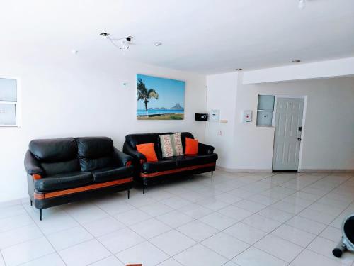 a living room with two black leather couches at Departamento 21, cama king, cocineta , cerca del CAS,CIMA, CRIT, centro de gobierno y galerias mall in Hermosillo