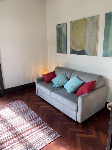 a living room with a couch with red and blue pillows at Cozy Nest in Bretanha