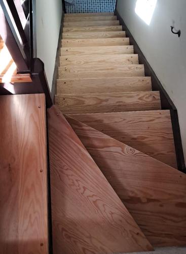 a staircase with wooden floors and a wooden door at Cozy Nest in Bretanha