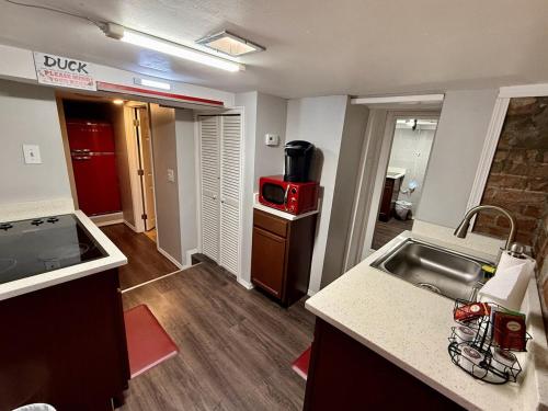 a small kitchen with a sink and a microwave at Charming Marmalade Flat in Downtown Salt Lake City in Salt Lake City