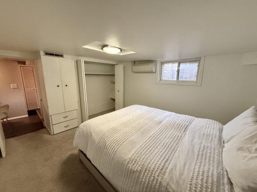 a bedroom with a white bed and a window at Charming Marmalade Flat in Downtown Salt Lake City in Salt Lake City