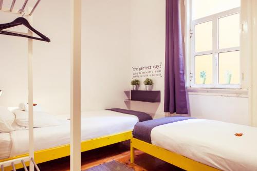 two beds in a room with a window at Lisbon Chillout Hostel Privates in Lisbon