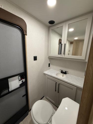 a small bathroom with a toilet and a sink at Stylish RV with 2 Bedrooms, 2 Lofts and 2 Bathrooms in Key Largo