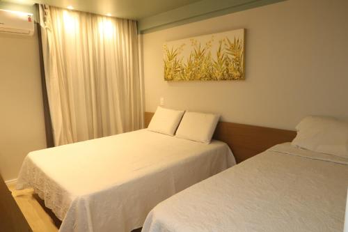 En eller flere senge i et værelse på Marupiara Suítes Muro alto Apts 319 e 224