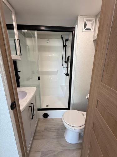 a small bathroom with a toilet and a shower at Stylish RV with 2 Bedrooms, 2 Lofts and 2 Bathrooms in Key Largo