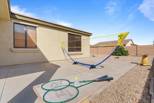 two tennis rackets sitting on a table in front of a house at Family Friendly w Badminton Goodyear Park in Goodyear