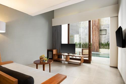 a living room with a couch and a tv at Dialoog Seminyak in Seminyak