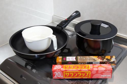 a frying pan on top of a stove with a pot at Isole le Olena 201 in Naha
