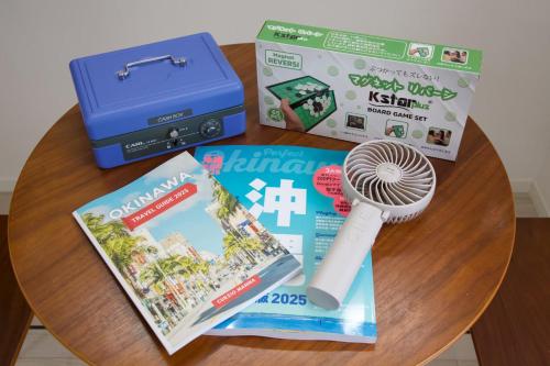 a table with books and a box and a thermometer at Isole le Olena 201 in Naha