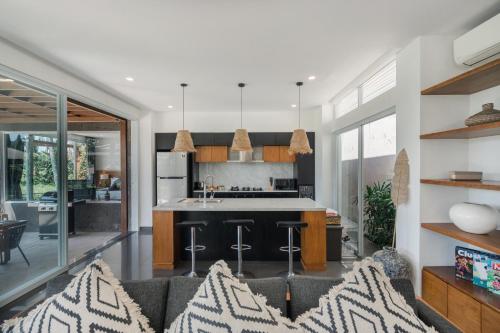 an open kitchen and living room with a couch at Coconut Grove Villa by Betterplace in Ubud