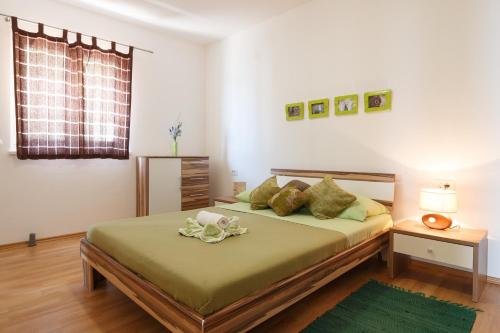 a bedroom with a bed with green sheets and a window at Apartments Villa Stari Koko in Omiš