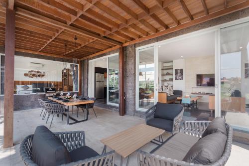 a living room with furniture and a dining room at Coconut Grove Villa by Betterplace in Ubud