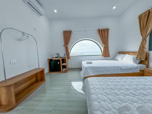 a bedroom with two beds and a window at D&T House in Cù Lao Thu