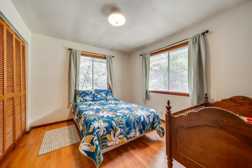 a bedroom with a bed and two windows at 2 Mi to Hawaii Volcanoes Natl Park Tranquil Home in Volcano