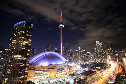 a view of a city at night with the cn tower at Downtown Toronto Suite By The Water in Toronto