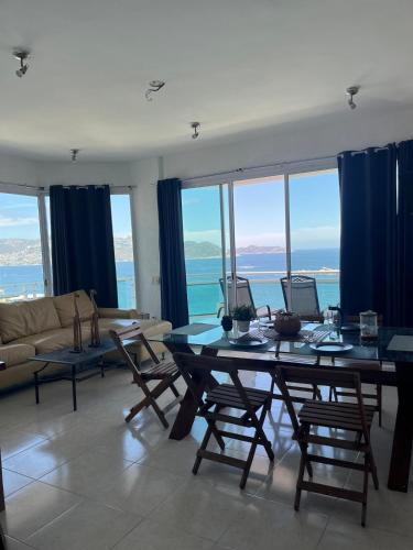 a living room with a couch and a table with chairs at apartment with sea and Island views in Acapulco