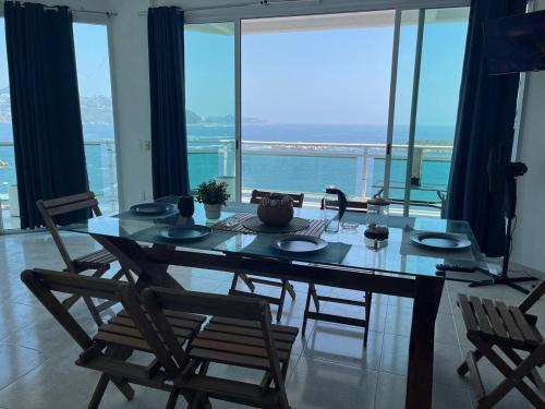 a dining room table with chairs and a view of the ocean at apartment with sea and Island views in Acapulco