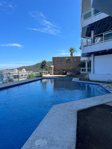 a swimming pool in front of a building at apartment with sea and Island views in Acapulco