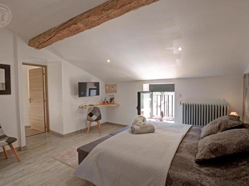 una camera da letto con un letto grande e una scrivania di Séjour paisible en gîte de charme avec spa en campagne - FR-1-496-334 a Saint-Julien-Molin-Molette