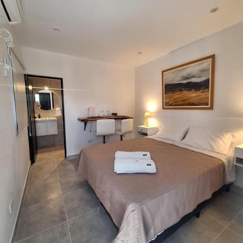 a bedroom with a bed and a bathroom with a sink at Pintó-apart in Cafayate
