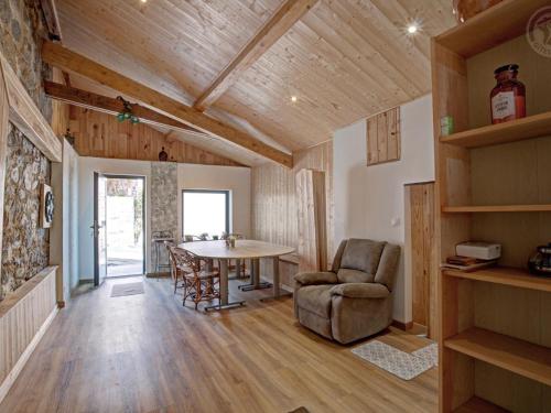 un salon avec une table et une chaise dans l'établissement Gîte de charme 18ème avec spa et terrasse, St-Julien-Molin-Molette - FR-1-496-335, à Saint-Julien-Molin-Molette