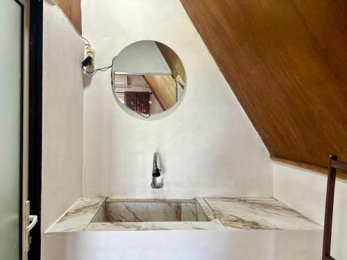 a bathroom with a marble sink and a mirror at Bello Bungalow in Batukliang