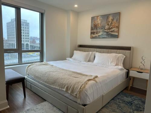 a bedroom with a large bed with a large window at Upscale 2BR Condo with Gym & Parking near MGH & TUFTS in Boston