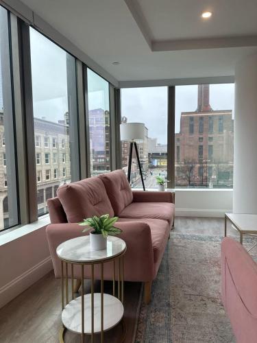 a living room with a couch and large windows at Upscale 2BR Condo with Gym & Parking near MGH & TUFTS in Boston