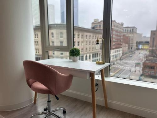 a desk and a chair in front of a window at Upscale 2BR Condo with Gym & Parking near MGH & TUFTS in Boston