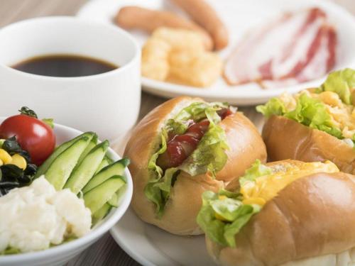 a table with plates of sandwiches and a cup of coffee at Premier Hotel Cabin Matsumoto in Matsumoto