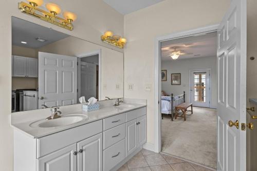 a white bathroom with a sink and a mirror at Harkers Haven home in Harkers Island
