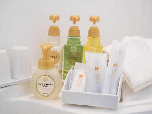 a shelf with three bottles of soap and toiletries at Premier Hotel Cabin Matsumoto in Matsumoto
