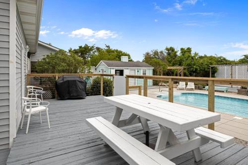a wooden deck with a picnic table and a pool at Harkers Haven home in Harkers Island