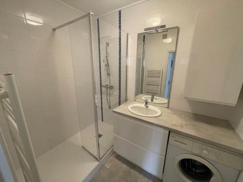 ein Badezimmer mit einer Dusche, einem Waschbecken und einer Waschmaschine in der Unterkunft T3 face plage avec balcon et parking, aux Sables-d'Olonne - FR-1-92-808 in Les Sables-dʼOlonne