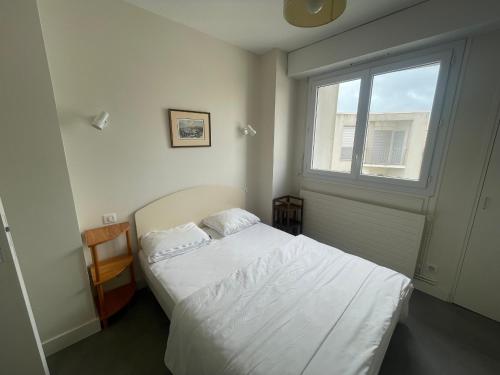 ein kleines Schlafzimmer mit einem Bett und einem Fenster in der Unterkunft T3 face plage avec balcon et parking, aux Sables-d'Olonne - FR-1-92-808 in Les Sables-dʼOlonne