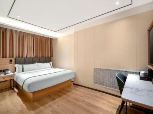 a bedroom with a bed and a table and a desk at GreenTree Inn Harbin Central Avenue in Harbin
