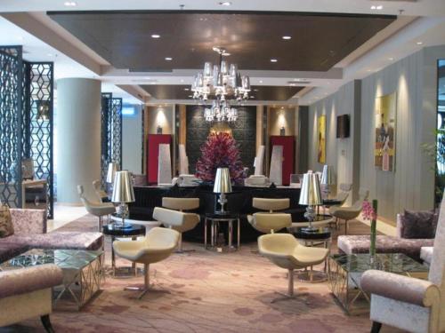 a lobby with chairs and tables and a chandelier at Ramada by Wyndham Xi'an Bell Tower in Xi'an