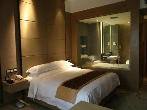 a hotel room with a large bed and a bathroom at Ramada by Wyndham Xi'an Bell Tower in Xi'an