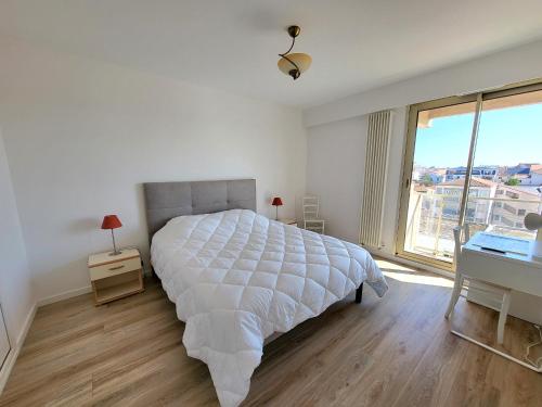 une chambre blanche avec un grand lit et une fenêtre dans l'établissement Appartement T3 rénové, face mer avec garage et WiFi, aux Sables d'Olonne - FR-1-92-919, à Les Sables-dʼOlonne