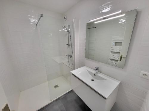 une salle de bain blanche avec un lavabo et une douche dans l'établissement Appartement T3 rénové, face mer avec garage et WiFi, aux Sables d'Olonne - FR-1-92-919, à Les Sables-dʼOlonne