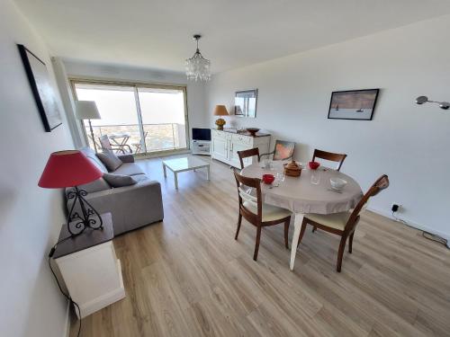 un salon avec une table et un canapé dans l'établissement Appartement T3 rénové, face mer avec garage et WiFi, aux Sables d'Olonne - FR-1-92-919, à Les Sables-dʼOlonne