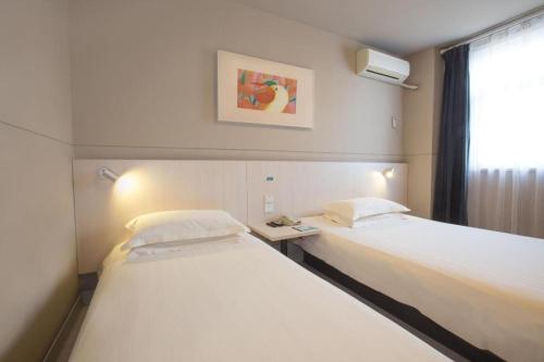 a hospital room with two beds and a window at Jinjiang Inn Luoyang Wangcheng Park Metro Station in Luoyang